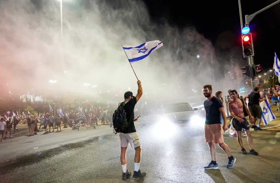 La policía israelí emplea un cañón de agua para dispersar a manifestantes que bloquean una calle en una protesta contra los planes del gobierno del primer ministro, Benjamin Netanyahu,  de reformar el sistema judicial, en Jerusalén, el domingo 23 de julio de 2023. Foto: AP / Ohad Zwigenberg.