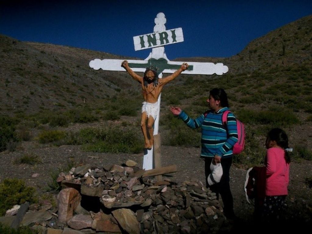 Los peregrinos a Punta Corral hacen un alto en el trayecto para orar y pedir la bendición al Cristo de la montaña.
