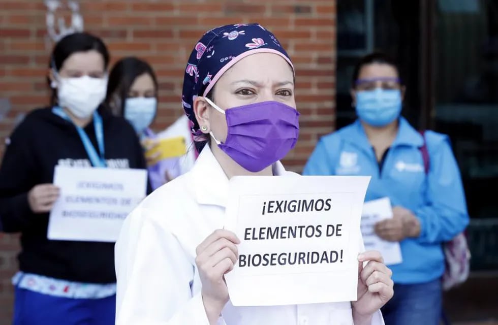 -FOTODELDÍA- AME6746. BOGOTÁ (COLOMBIA), 30/04/2020.- Médicos y enfermeras del Hospital de Kennedy, uno de los más grandes de Bogotá, sostienen carteles durante una protesta pidiendo al Gobierno garantías laborales y elementos de protección adecuados para enfrentar la pandemia del coronavirus este jueves en Bogotá (Colombia). EFE/ Mauricio Dueñas Castañeda