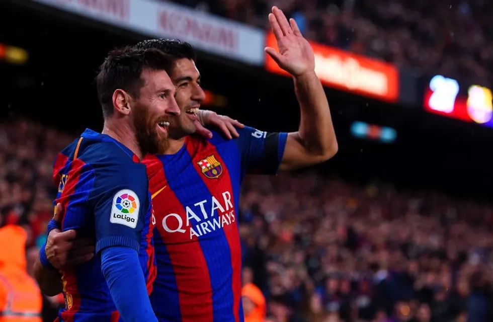 Barcelona's Argentinian forward Lionel Messi (L) is congratulated by Barcelona's Uruguayan forward Luis Suarez after scoring during the Spanish league football match FC Barcelona vs Sevilla FC at the Camp Nou stadium in Barcelona on April 5, 2017. / AFP P