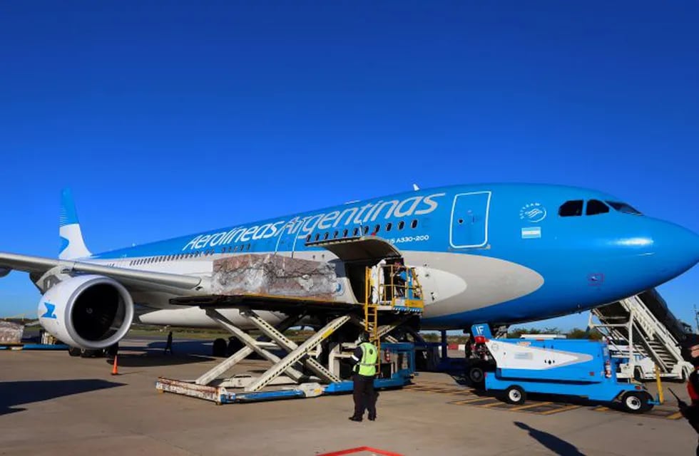 Handout picture released by the Buenos Aires province Ministry of Public Communication  showing workers unloading boxes containing medical supplies coming from China on an Aerolineas Argentinas airplane upon its landing at Ezeiza airport in Buenos Aires on April 18, 2020. (Photo by MARIANO SANDA / Buenos Aires province Ministry of Public Communication / AFP) / RESTRICTED TO EDITORIAL USE - MANDATORY CREDIT AFP PHOTO / BUENOS AIRES PROVINCE MINISTRY OF PUBLIC COMMUNICATION / MARIANO SANDA - NO MARKETING NO ADVERTISING CAMPAIGNS - DISTRIBUTED AS A SERVICE TO CLIENTS