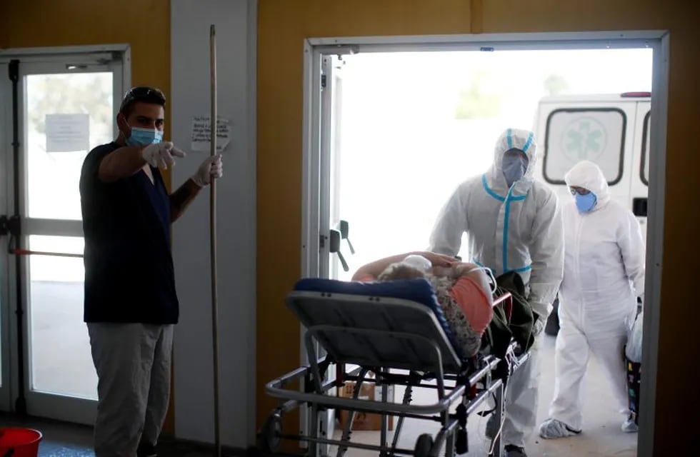 Health workers enter a stretcher with a COVID-19 patient at a hospital in Mar del Plata, Argentina, Saturday, Oct. 10, 2020. (AP Photo/Natacha Pisarenko)