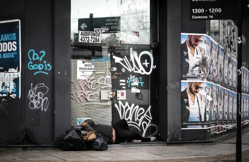 Un hombre duerme frente a un local cerrado a causa de la crisis económica (EFE)