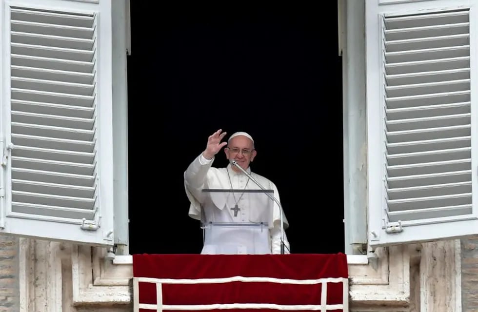 Pope Francis waves to pilgrims during the Angelus prayer in Saint Peter's square at the Vatican on January 7,2018. / AFP PHOTO / TIZIANA FABI