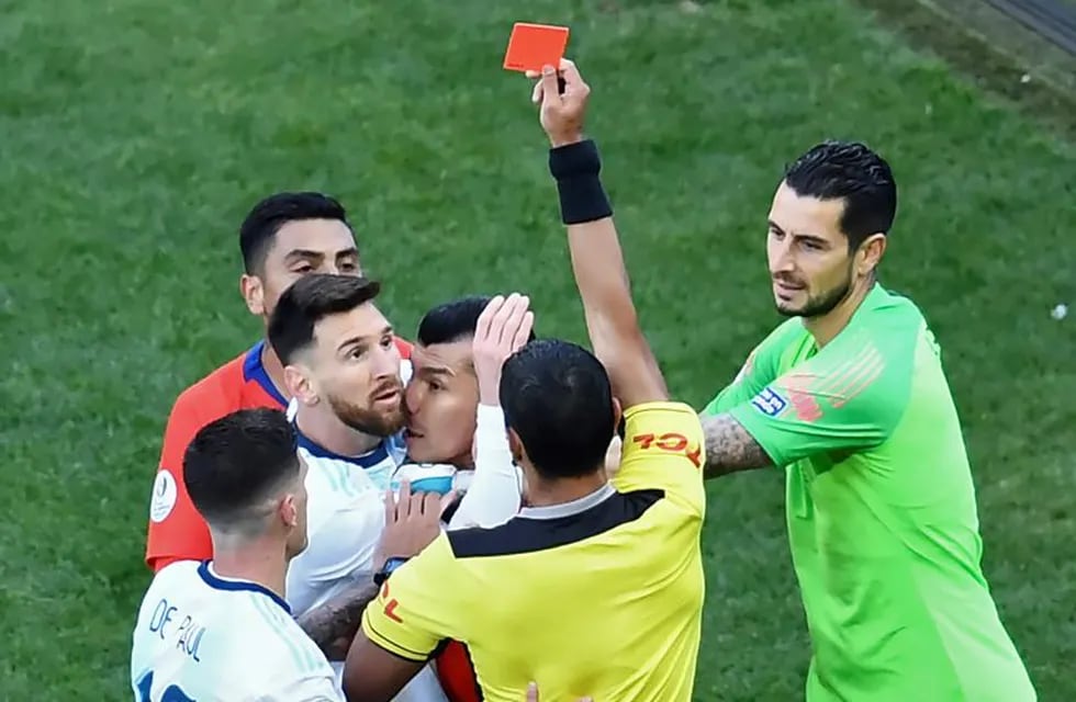 Paraguayan referee Mario Diaz de Vivar shows the red card to Argentina's Lionel Messi and Chile's Gary Medel as they have a physical encounter during the Copa America football tournament third-place match at the Corinthians Arena in Sao Paulo, Brazil, on July 6, 2019. (Photo by EVARISTO SA / AFP)