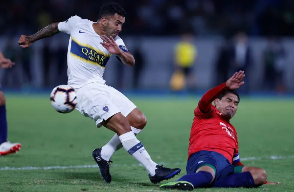 Carlos Tevez of Argentina's Boca Juniors, left, fights for the ball with Edward Zenteno of Bolivia's Jorge Wilstermann during a Copa Libertadores soccer match in Cochabamba, Bolivia, Tuesday, March 5, 2019. (AP Photo/Juan Karita)