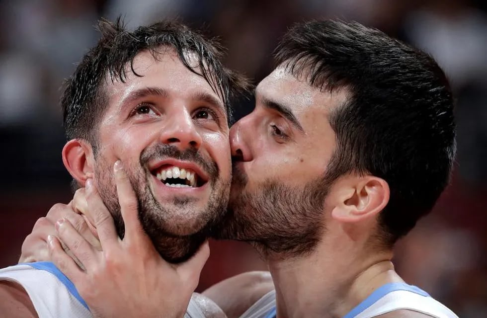 Facundo Campazzo of Argentina, right, kisses teammate Nicolas Laprovittola as they celebrate after beating France in their semifinal match against in the FIBA Basketball World Cup at the Cadillac Arena in Beijing, Friday, Sept. 13, 2019. (AP Photo/Mark Schiefelbein)