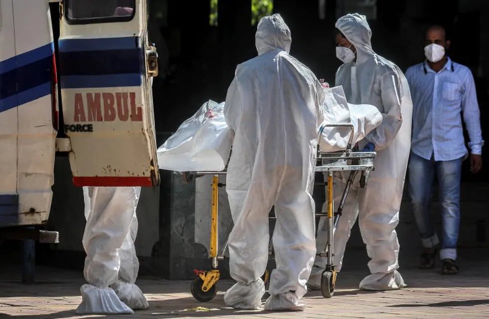 Mumbai (India), 10/06/2020.- Indian health workers wearing Personal Protective Equipment (PPE) carry a corpse of a COVID-19 victim, at Dahanukar wadi crematorium, in Mumbai, India, 10 June 2020. According to media reports, the number of confirmed cases of coronavirus in Mumbai crossed 50,000 cases on 10 June. EFE/EPA/DIVYAKANT SOLANKI
