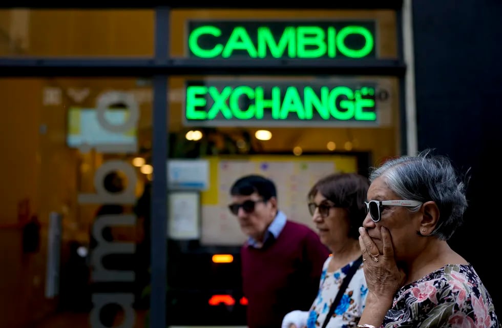 Las personas caminan frente a una casa de cambio en Buenos Aires, Argentina. (AP Foto/Natacha Pisarenko)