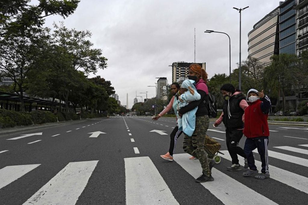 Una familia cruza la Avenida 9 de Julio (Foto: JUAN MABROMATA / AFP)