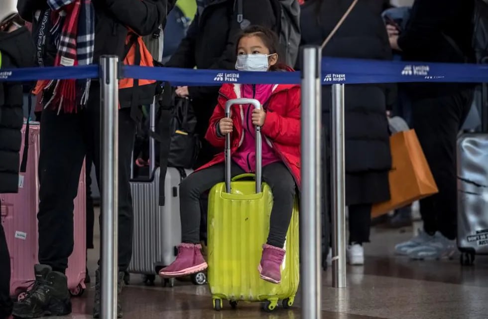 Prague (Czech Republic), 27/01/2020.- A child wears mask as she sits on her luggage at a check-in area of the Vaclav Havel airport in Prague, Czech Republic, 27 January 2020. The Prague Airport started screening incoming passengers from China and placed information signs at the terminals advising what passengers should do when they arrive from areas affected by the coronavirus outbreak and showing signs of illness. Authorities around the world are stepping up measures to deter the spread of the coronavirus, which was reported first in China's Hubei province. (República Checa, Praga) EFE/EPA/MARTIN DIVISEK