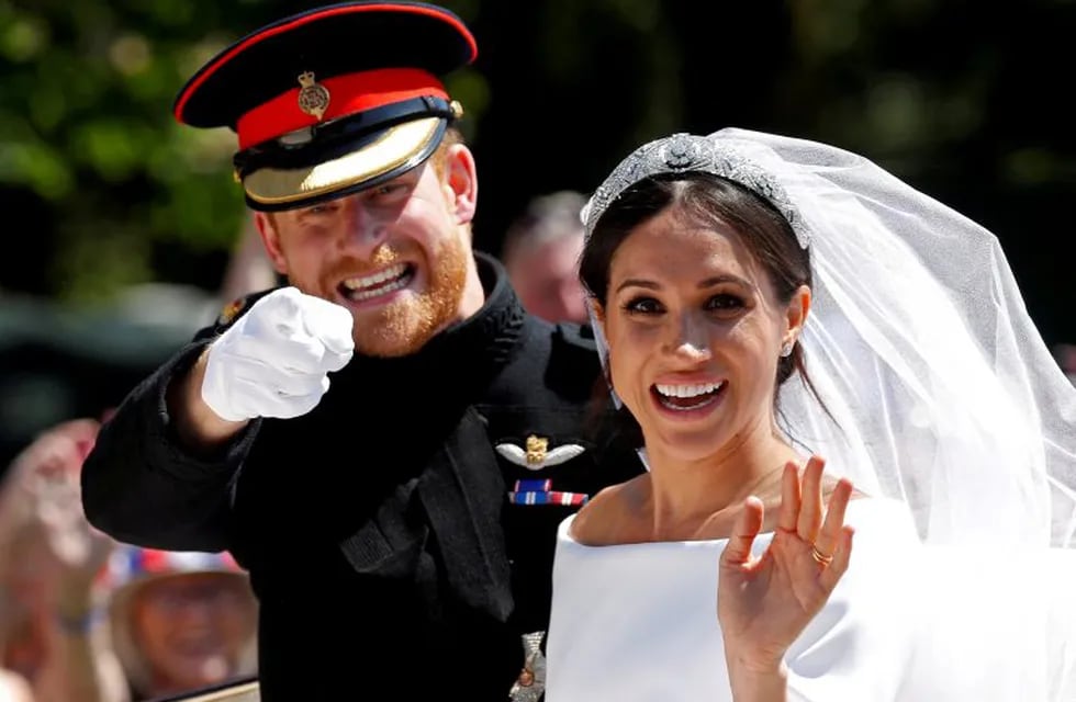 FILE PHOTO: Britain's Prince Harry gestures next to his wife Meghan as they ride a horse-drawn carriage after their wedding ceremony at St George's Chapel in Windsor Castle in Windsor, Britain, May 19, 2018. REUTERS/Damir Sagolj/File Photo