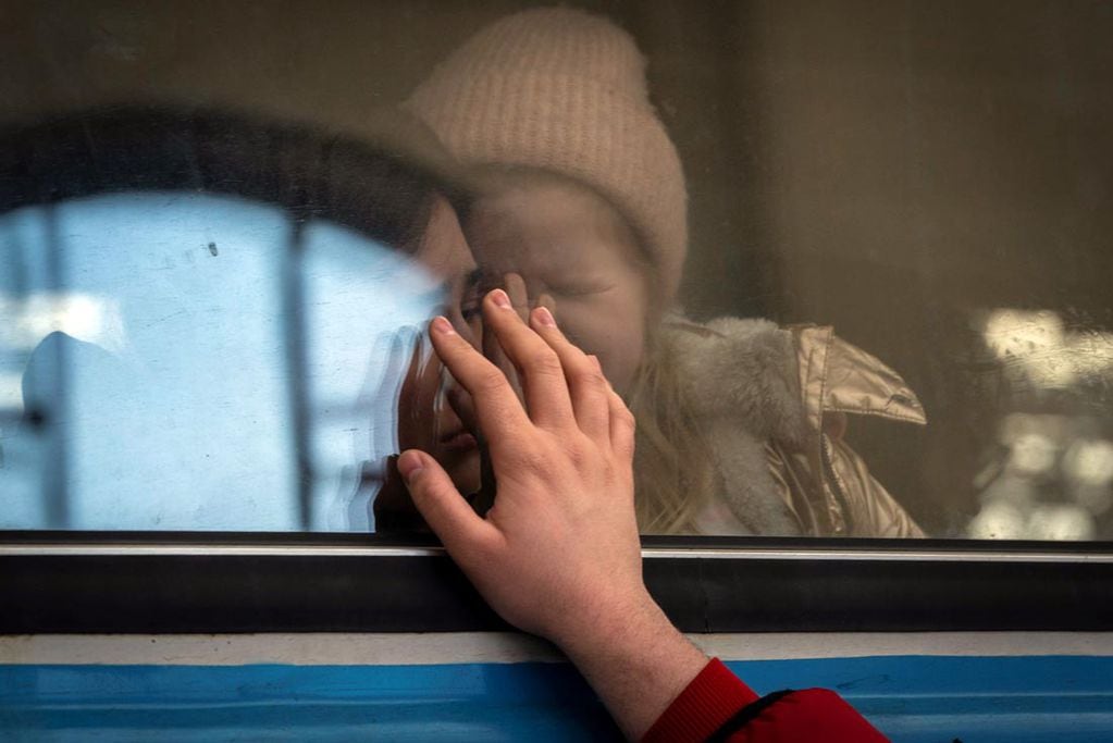 Ucranianos desplazados en un tren con destino a Polonia se despiden en Lviv. (AP /Bernat Armangue)