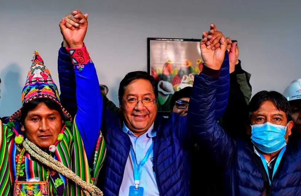 TOPSHOT - Bolivia's leftist presidential candidate Luis Arce (C), of the Movement for Socialism party, celebrates with running mate David Choquehuanca (R) early on October 19, 2020, in La Paz, Bolivia. - Bolivian presidential candidate Luis Arce, the leftist heir to former leader Evo Morales, appeared headed to a first-round election victory on October 18, 2020 with 52.4 percent of the vote, according to an authoritative exit poll from TV station Unitel. (Photo by RONALDO SCHEMIDT / AFP)