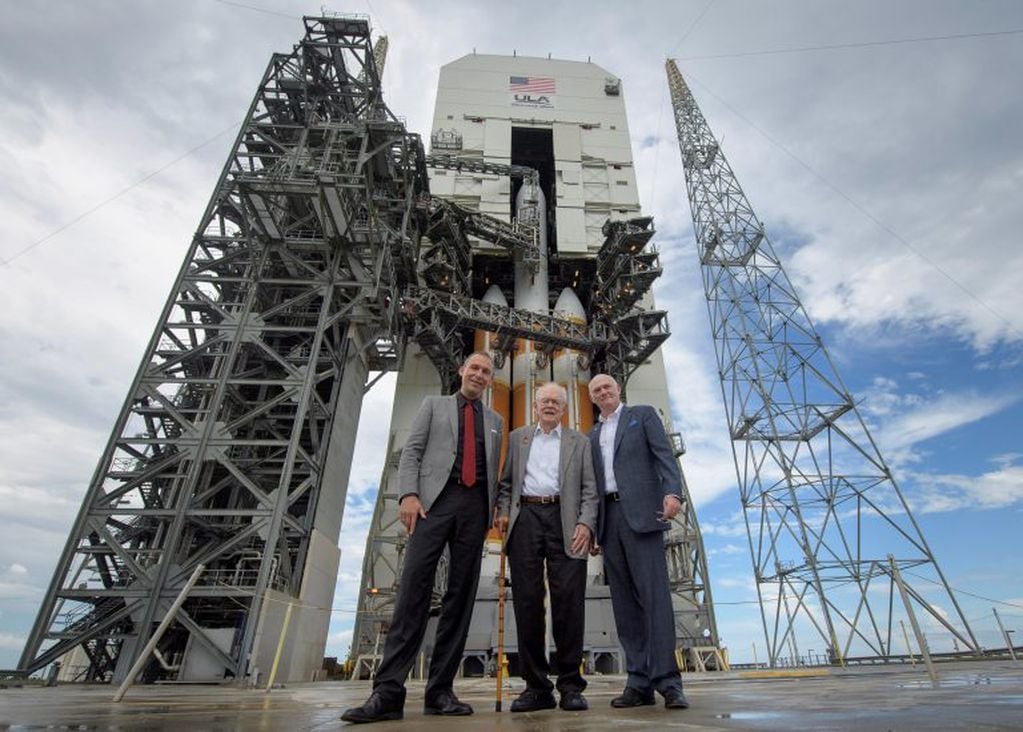 Eugene Parker, en el centro, posa frente al cohete que llevará a la sonda nombrada en su honor a "rozar" al Sol. Crédito: NASA/Bill Ingalls.
