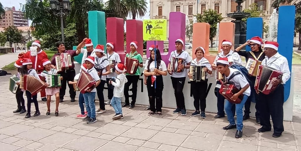 La delegación del Centro Cultural del Acordeón de Humahuaca, posa para turistas y vecinos capitalinos, a su paso por la plaza Belgrano, en San Salvador de Jujuy.