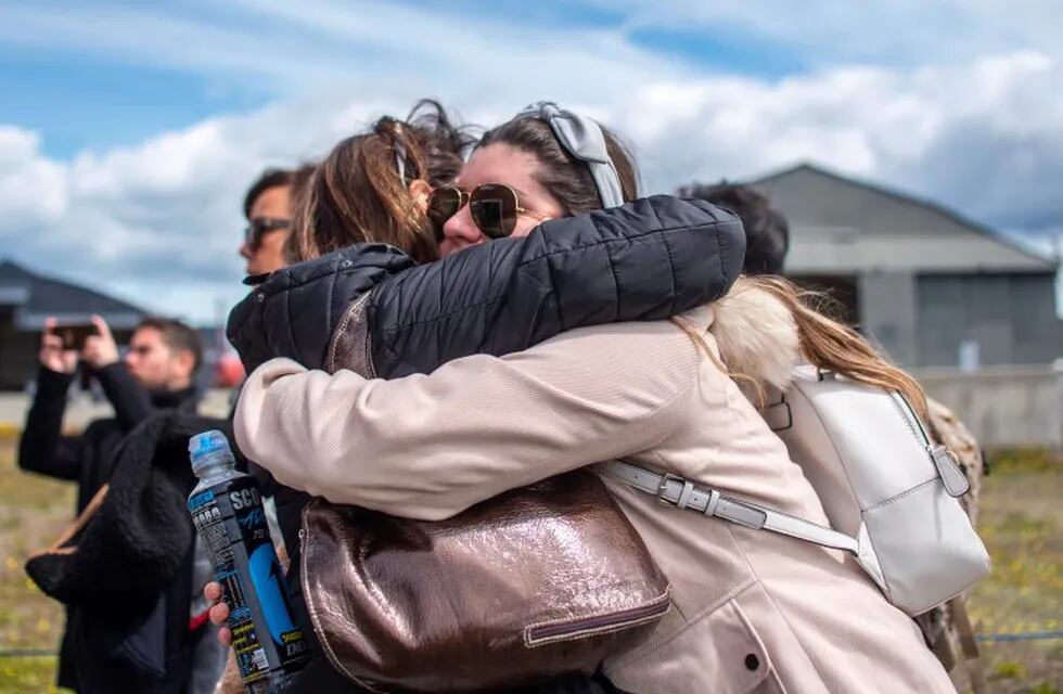 Relatives of people aboard the Chilean Air Force C-130 Hercules cargo plane that went missing in the sea between the southern tip of South America and Antarctica, embrace at Chabunco army base in Punta Arenas, Chile, on December 11, 2019. - Rescue planes and ships on Tuesday searched the open sea between the southern tip of South America and Antarctica for a Chilean Air Force plane that went missing with 38 people aboard. (Photo by Joel ESTAY / AFP)