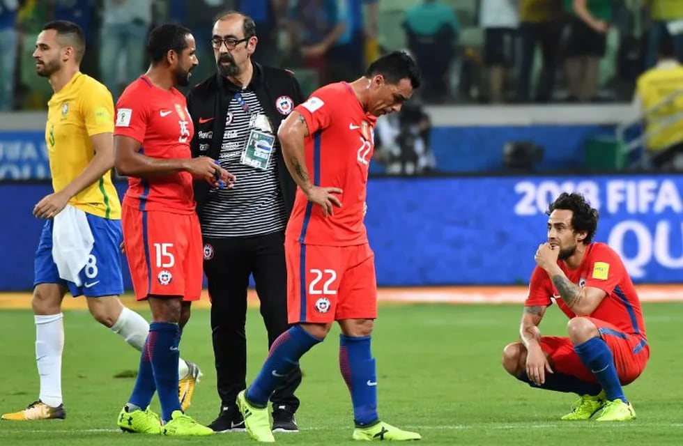 Chile's Jean Beausejour (2-L), Esteban Paredes (C) and Jorge Valdivia (R) show their dejection after being defeated by Brazil in a qualifier match and missing the 2018 World Cup football tournament, in Sao Paulo, Brazil, on October 10, 2017. / AFP PHOTO / Nelson ALMEIDA
