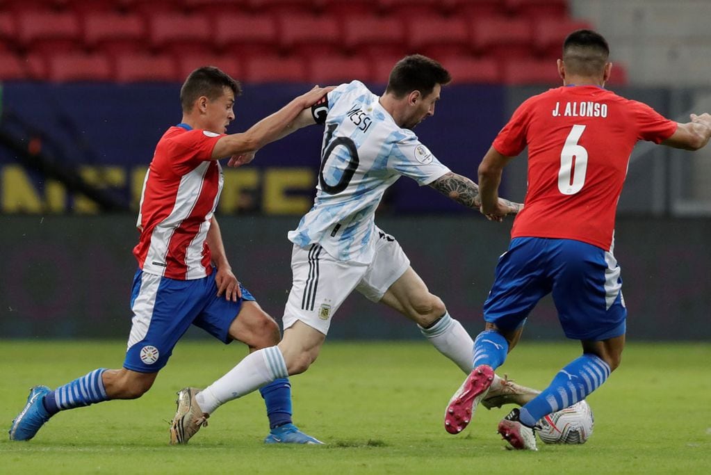 Lionel Messi pretende prosperar ante la marca de Alonso y Cubas, de Paraguay. Argentina jugó en Brasilia por la Copa América. (AP)