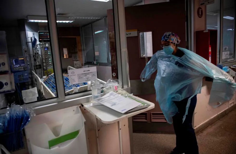 A doctor puts a protective gown as she gets ready to check patients at the Intensive Care Unit of the Barros Luco Hospital in Santiago, on July 22, 2020 amid the COVID-19 novel coronavirus pandemic. (Photo by Martin BERNETTI / AFP)