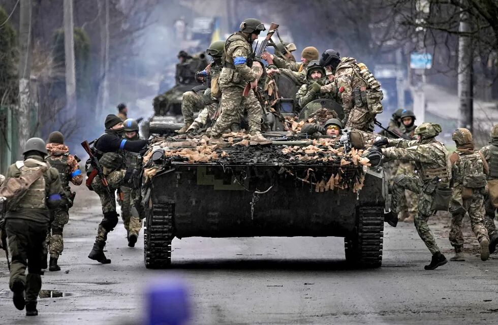 Militares ucranianos suben a un vehículo de combate en las afueras de Kiev, Ucrania, el sábado 2 de abril de 2022. A medida que las fuerzas rusas se retiran de la región de la capital de Ucrania, las tropas en retirada crean una situación "catastrófica" para los civiles al dejar minas abandonadas alrededor de las casas, equipo e "incluso los cuerpos de los asesinados", advirtió el sábado el presidente Volodymyr Zelenskyy.(AP)
