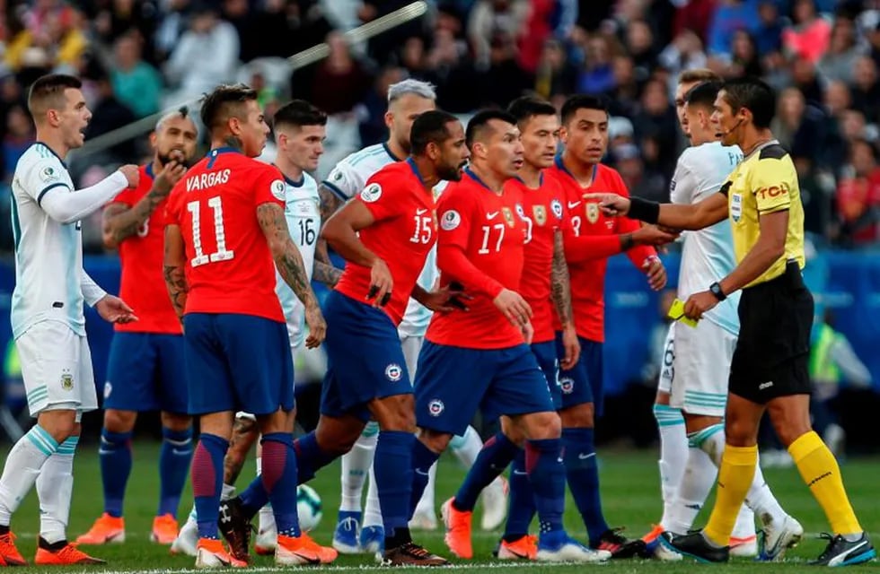 Paraguayan referee Mario Diaz de Vivar is surrounded by players after showing the red card to Argentina's Lionel Messi and Chile's Gary Medel during the Copa America football tournament third-place match at the Corinthians Arena in Sao Paulo, Brazil, on July 6, 2019. (Photo by Miguel SCHINCARIOL / AFP)