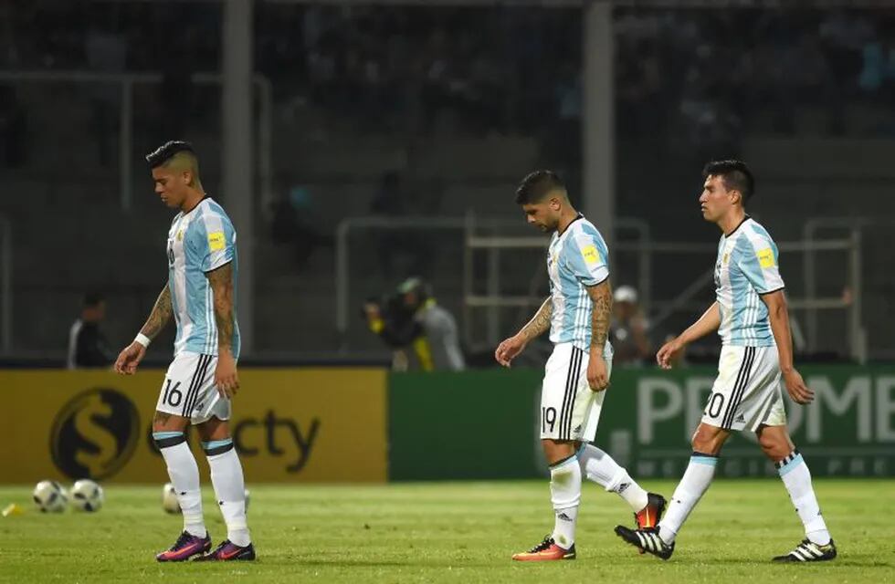 (L-R) Argentina's Marcos Rojo, Argentina's Ever Banega and Argentina's Nicolas Gaitan leave the field after the first half of the Russia 2018 World Cup football qualifier match against Paraguay in Cordoba, Argentina, on October 11, 2016. / AFP PHOTO / EIT