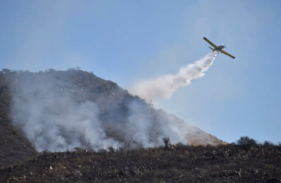 La Calera.  Aviones hidrantes trabajan para extinguir un incendio forestal intencional en barrio Rumi.   (Ramiro Pereyra)