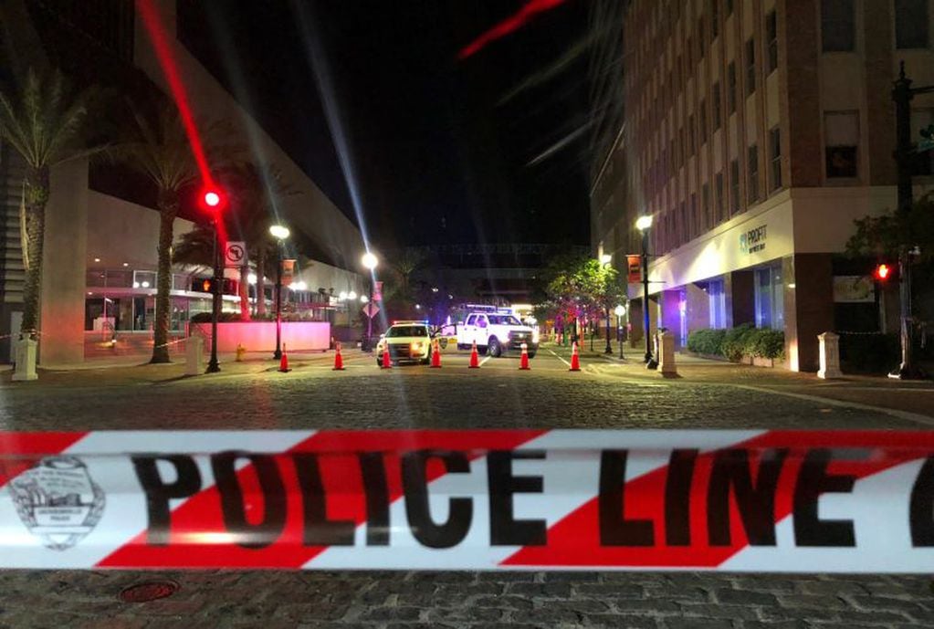 TOPSHOT - This photo shows a police car behind police tape blocking a street leading to the Jacksonville Landing area in downtown Jacksonville, Florida, August 26, 2018, where three people were killed, including the gunman, and 11 others wounded. - Two people were killed and 11 others wounded on August 26 when a video game tournament competitor went on a shooting rampage before turning the gun on himself in the northern Florida city of Jacksonville, local police said. Sheriff Mike Williams named the suspect of the shooting at a Madden 19 American football eSports tournament as 24-year-old David Katz from Baltimore, Maryland. (Photo by Gianrigo MARLETTA / AFP)