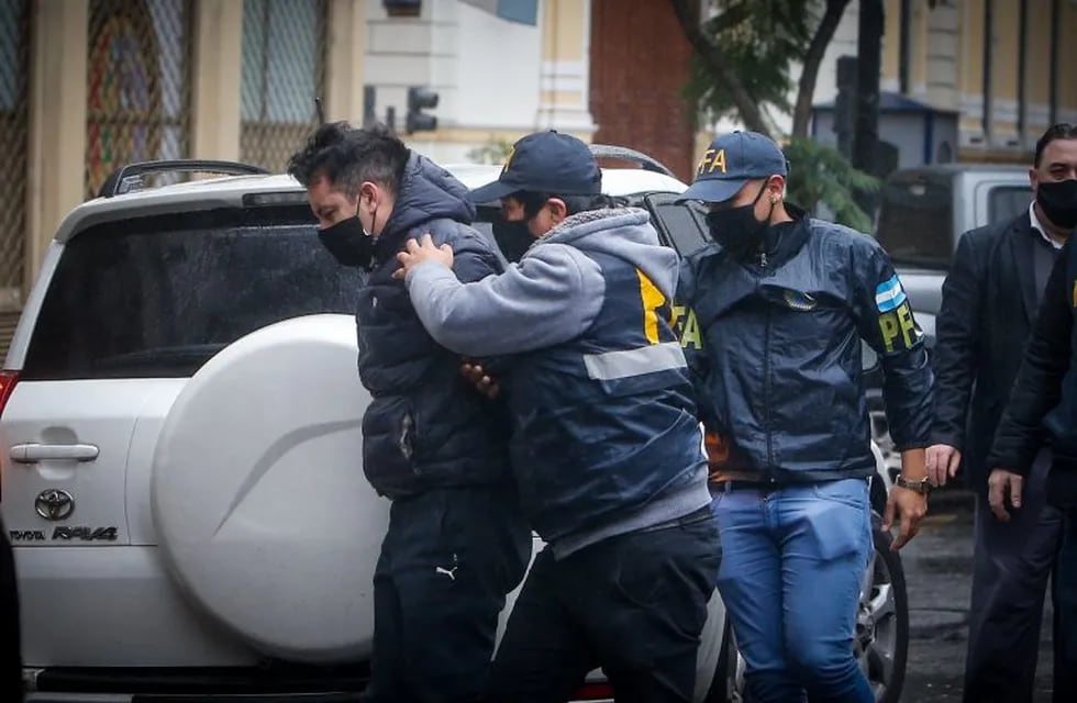 Miembros de la policía custodian hoy martes el traslado de Facundo Melo imputado en la causa de espionaje que involucra al expresidente Mauricio Macri. (EFE)