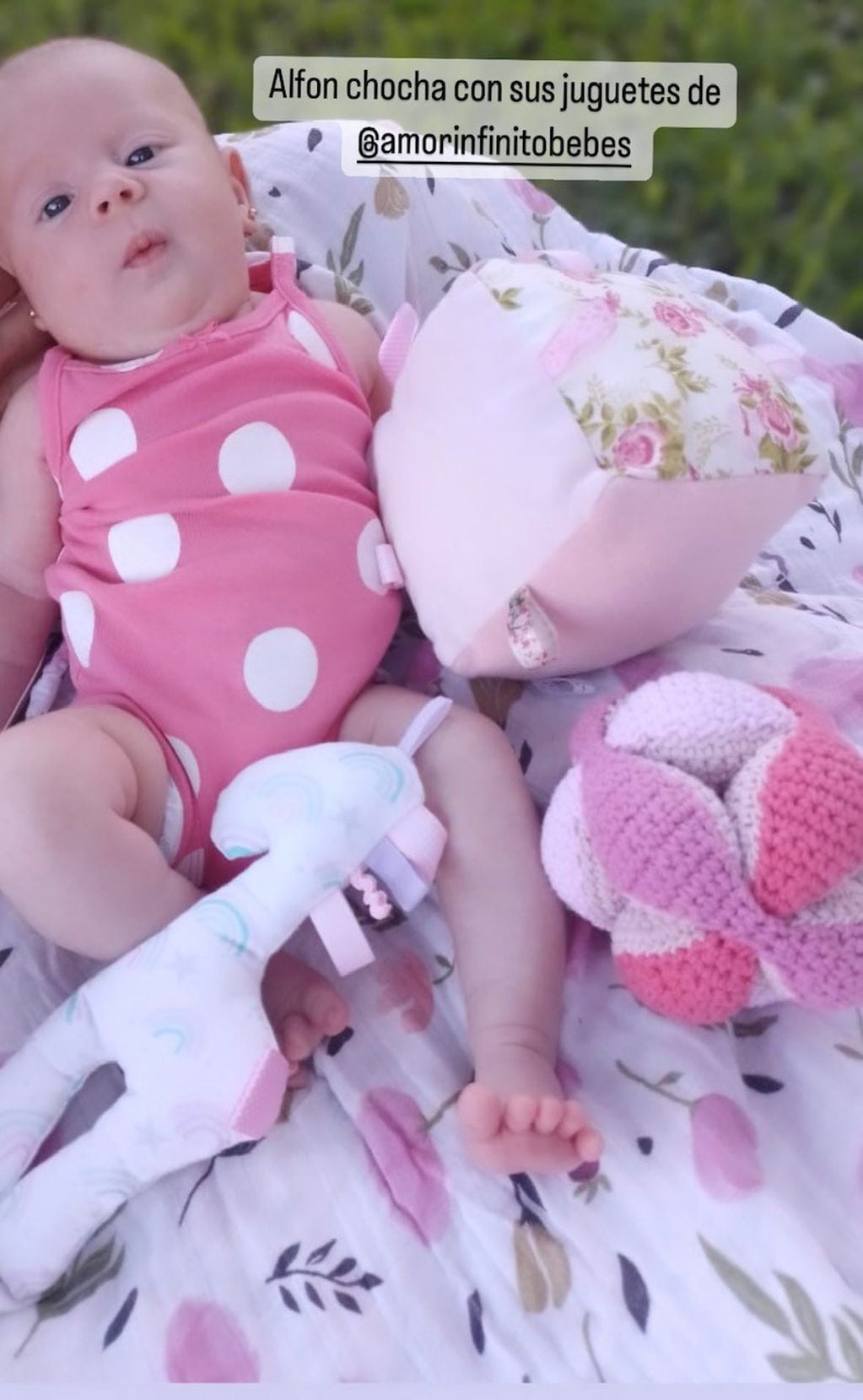 La beba combina sus bodys con juguetes en el mismo tono rosa.