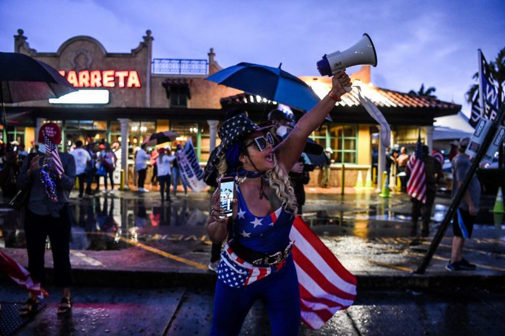 Seguidora de Trump sostiene una bandera de Estados Unidos en una protesta en Miami (Foto: CHANDAN KHANNA / AFP)