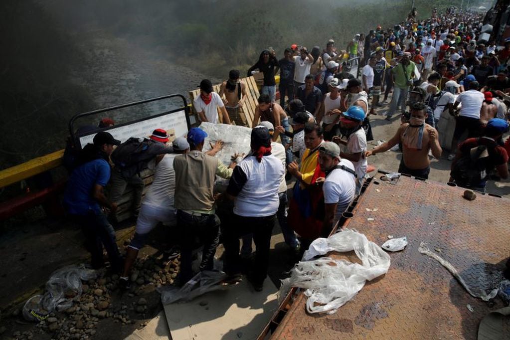 Las personas intentan salvar la ayuda humanitaria antes que se incendie en el puente de Cucuta, en la frontera con Venezuela (REUTERS/Marco Bello)
