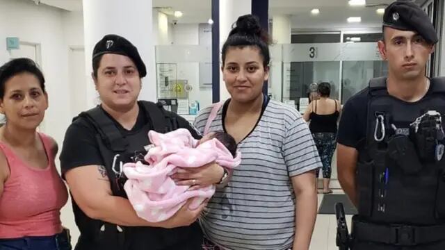 La bebé rescatada posa con los oficiales