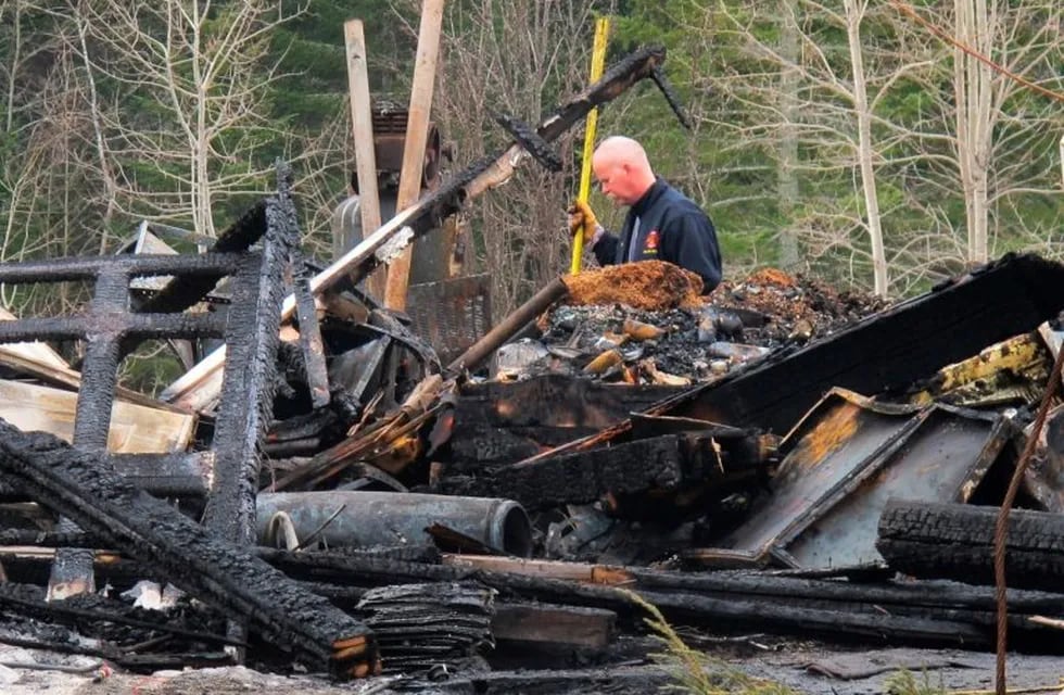 An Orland firefighter checks on burning hotspots Tuesday, Feb. 5, 2019, in the rubble of a house that burned to the ground the night before, in Orland, Maine. Investigators say a  man died when he returned to the burning house to get his dog.   (Bill Trotter/The Bangor Daily News via AP)