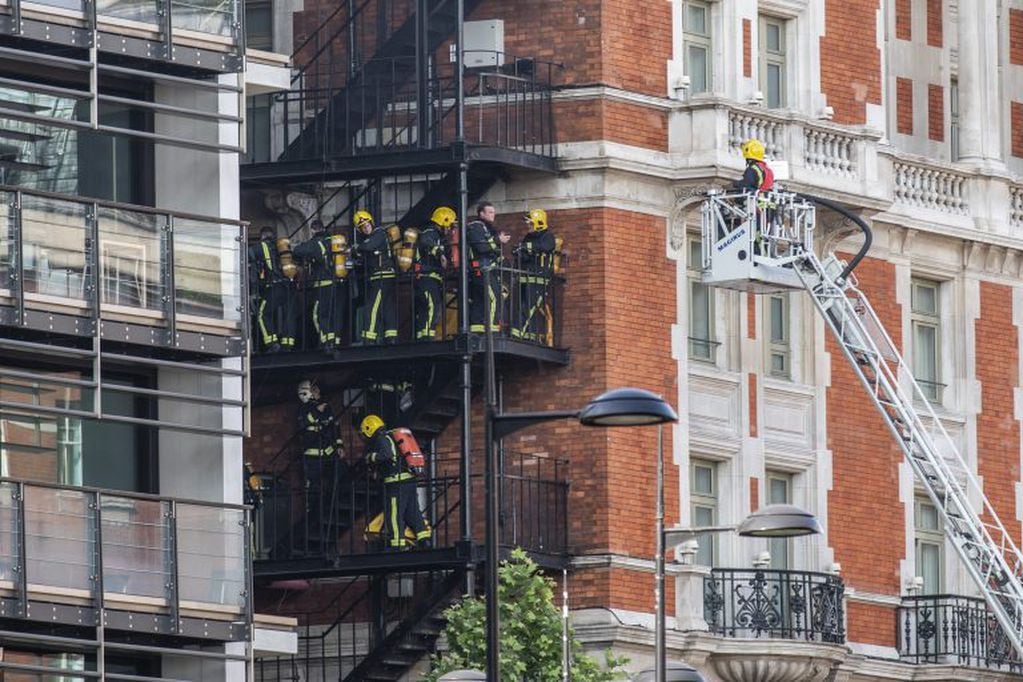 Los bomberos trabajan durante el operativo por un incendio en un hotel. Foto: Rob Pinney