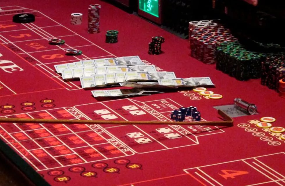 This June 24, 2016 photo shows cash, chips and dice on a craps table during a game at the Golden Nugget casino in Atlantic City, N.J. On June 16, 2020, the American Gaming Association, the casino industry's national trade group, called on state gambling regulators to make it easier for gamblers to use cashless betting options during the coronavirus outbreak. (AP Photo/Wayne Parry)