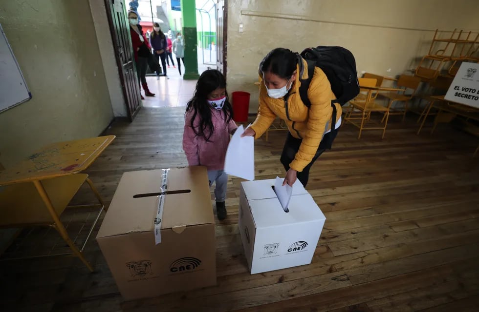 Una niña acompaña a una mujer a votar hoy en un centro electoral en Quito (Ecuador). (Foto: EFE/ José Jácome)