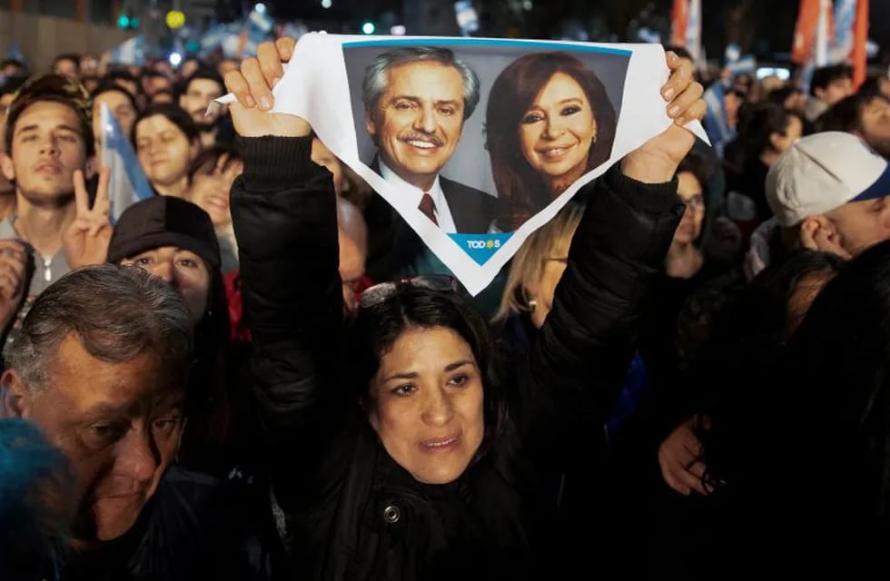 A supporter of presidential candidate Alberto Fernandez holds up a handkerchief with photos of him and his running-mate, former President Cristina Fernandez, outside the \