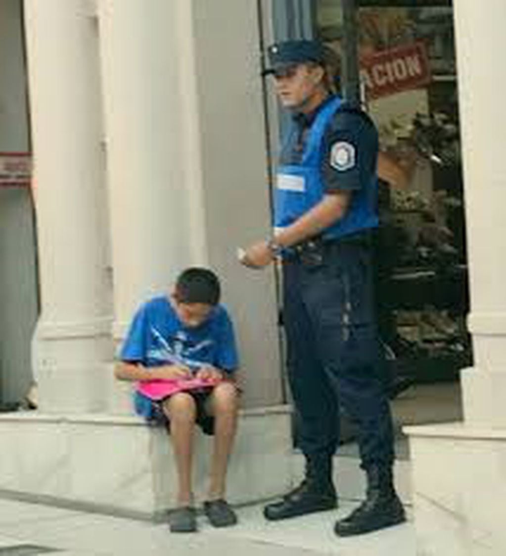 La historia detrás de la foto viral del policía ayudando a estudiar a un chico.