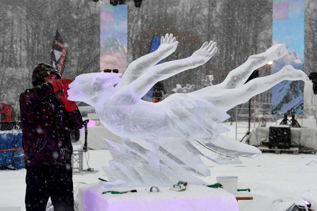 El escultor ruso Andrey Molokov trabaja en su obra "Flying in a Dream" (Volando en un sueño) (Foto de JEAN-PIERRE CLATOT / AFP)