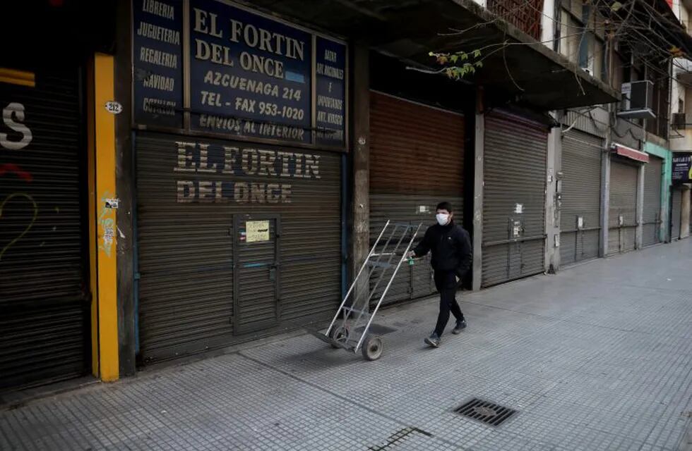 A man pushes a dolly past shuttered businesses amid the new coronavirus pandemic, in Buenos Aires, Argentina, Friday, June 26, 2020. Argentine President Alberto Fernandez is expected to announce a rollback on restrictions of the COVID-19 lockdowns in place since March 20th. (AP Photo/Natacha Pisarenko)   negocios cerrados en once negocio comercio comercios