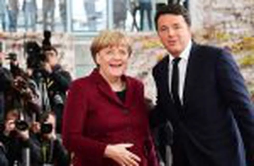 (FILES) This file photo taken on November 18, 2016 shows German Chancellor Angela Merkel greeting Italian Prime Minister Matteo Renzi ahead of a meeting with EU leaders and the US President at the Chancellery on November 18, 2016 in Berlin. Italian Prime 