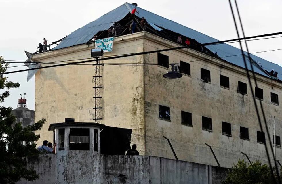 Inmates protest on the roof of Villa Devoto prison demanding measures to prevent the spread of the Covid-19 coronavirus, after a case was reported inside the detention center,  in Buenos Aires on April 24, 2020. (Photo by JUAN MABROMATA / AFP)