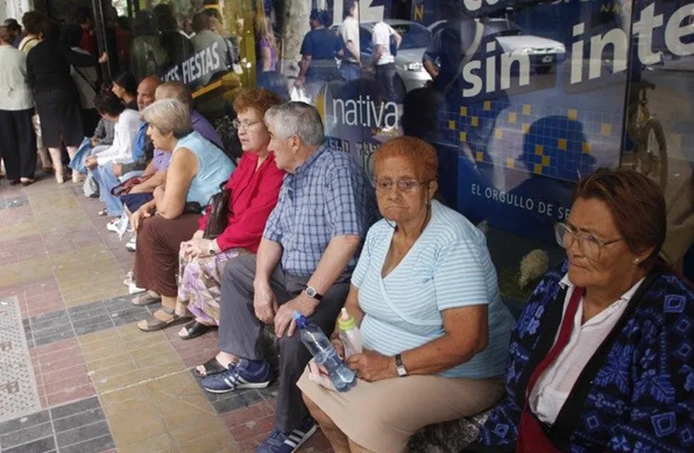 Jubilados aguardan para ser atendidos en un banco. (Archivo)