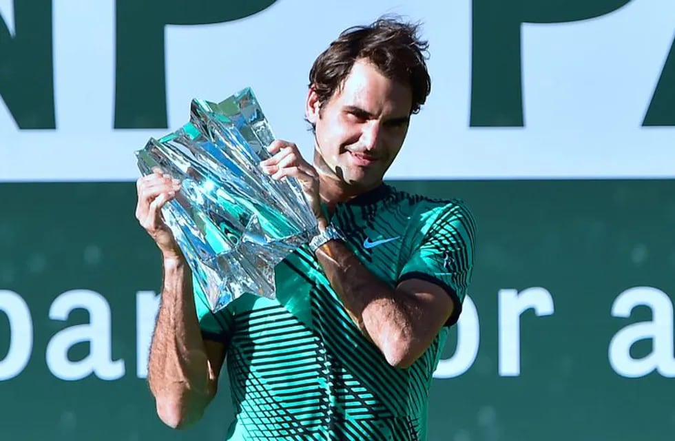 Roger Federer of Switzerland lifts the trophy following victory over compatriot Stan Wawrinka in the men's singles final at the ATP Indian Wells Masters in Indian Wells, California on March 19, 2017.nFederer defeated Wawrinka 6-4, 7-5. / AFP PHOTO / FREDE
