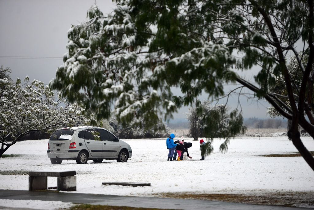 Una intensa nevada cayó en la provincia de Córdoba durante la noche y parte de la mañana del miércoles. 
Parque de los Niños Urbanos, frente al aeropuerto.  Familias juegan y arman muñecos de nieve.  (Nicolás Bravo)
