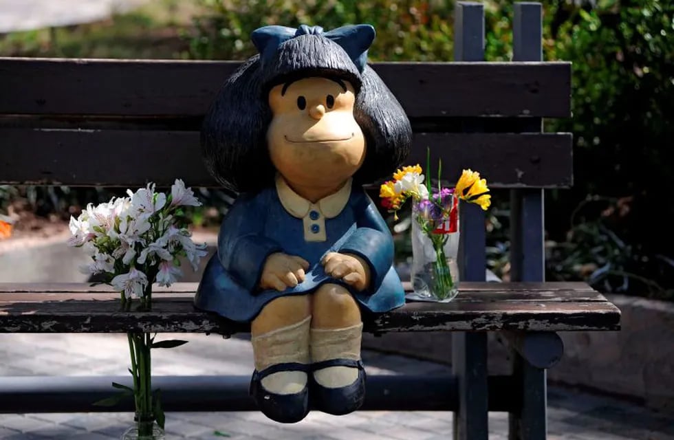 TOPSHOT - Flowers are seen by a statue depicting Mafalda, a comic strip character created by Argentinian cartoonist Joaquin Salvador Lavado, known as Quino, in Mendoza, Argentina, on September 30, 2020, on the day of his death. - Quino passed away Wednesday at 88, his editor confirmed. (Photo by Andres LARROVERE / AFP)