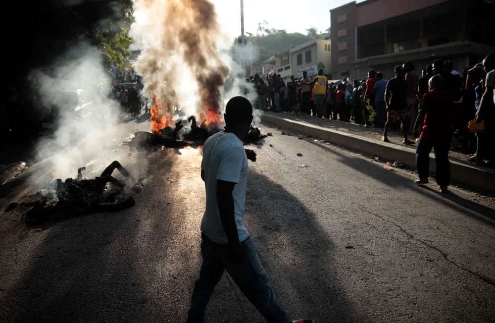 Un grupo de personas observa los cadáveres de presuntos pandilleros que fueron quemados vivos por una turba en la sección Canape Vert de Puerto Príncipe, Haití, el lunes 24 de abril de 2023. Foto: AP / Odelyn Joseph,