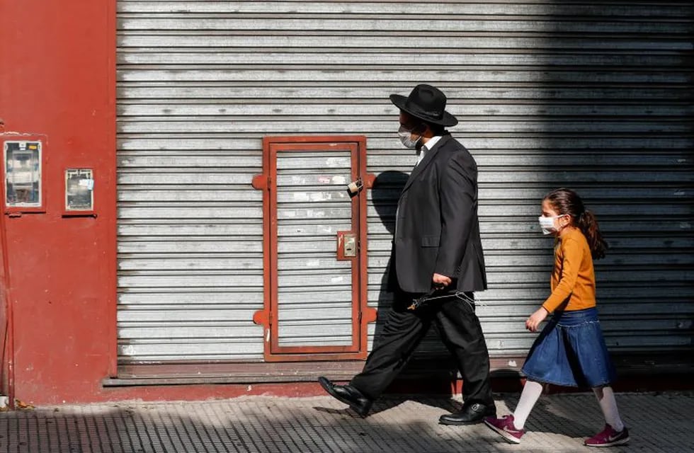 Jewish community members wear face masks as they walk outside a closed store, as Argentina works to organize arrival of a rabbis' delegation from Israel to keep kosher beef lines going in the midst of the coronavirus disease (COVID-19) outbreak, in Buenos Aires, Argentina May 20, 2020. REUTERS/Agustin Marcarian
